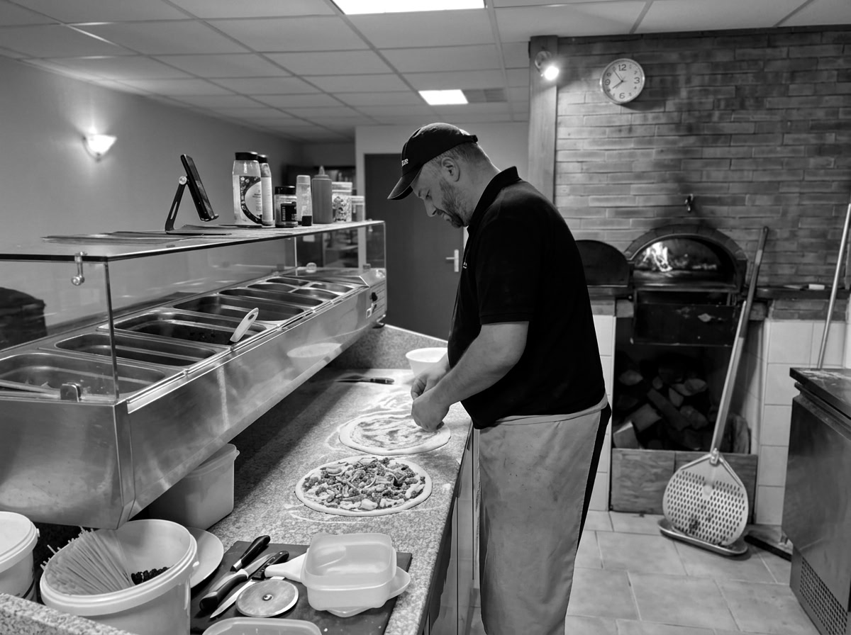 Pizzaïolo Pizza'y'olo devant le four à bois à Uxegney